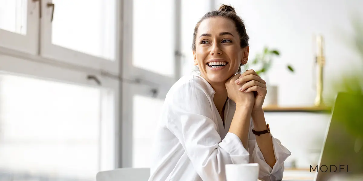 Woman Smiling in a Modern Apartment by Window