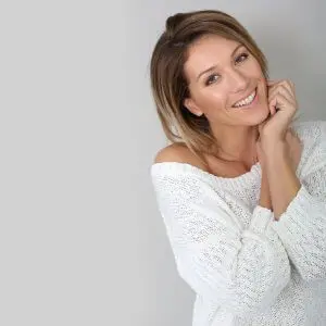 Woman poses in front of a light gray background