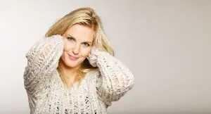 Skincare Model in White Sweater in Front of a Pale Tan Background