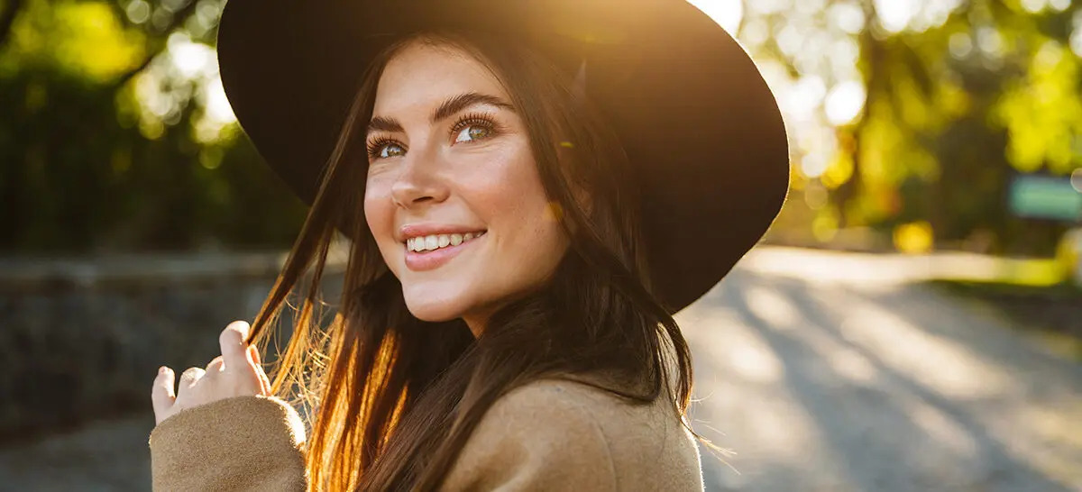 Woman outside smiling after putting sunscreen on