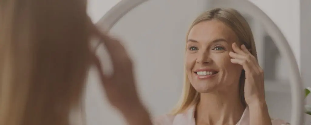 Woman looking in mirror that wants Juvéderm