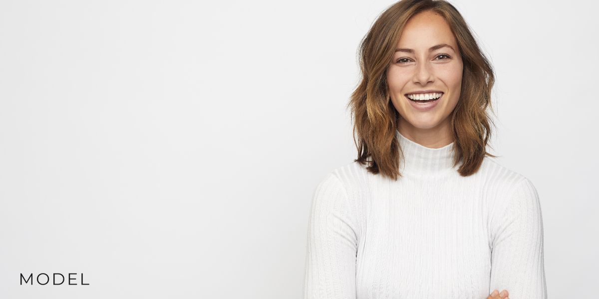 Smiling Woman in White Sweater against White Background
