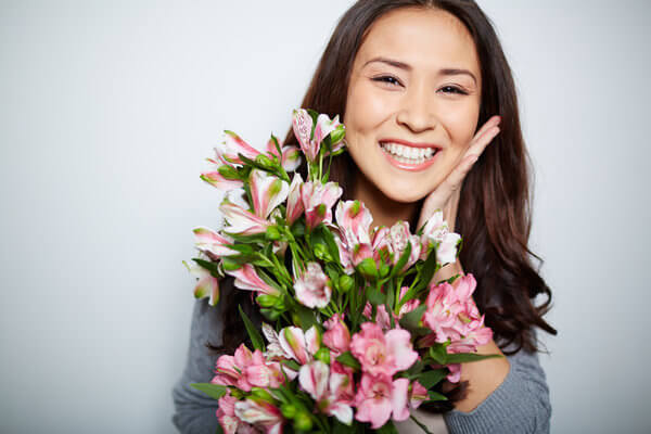 Model Smiling While Holding Flowers