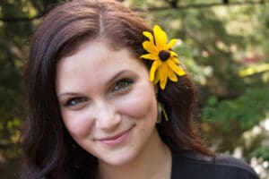 Woman Model with Flower in Hair Grinning in the Woods