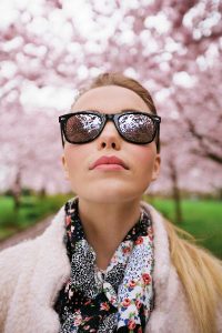 Woman in Sunglasses Surrounded by Cherry Blossoms