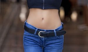Model Demonstrating a Flat Stomach between a Black top and Jeans