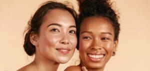 An Asian Woman and an African American Woman smiling after cosmetic procedure